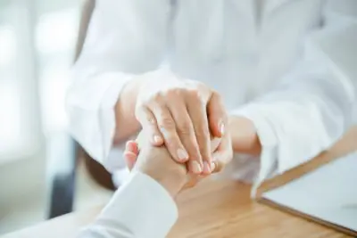 doctor holding patient's hand